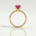 Lulu solitaire engagement ring in 18k yellow gold with an elongated cushion pink lab-grown sapphire centre stone, side profile showing the setting and band.