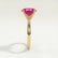 Lulu solitaire engagement ring in 18k yellow gold with an elongated cushion pink lab-grown sapphire centre stone, end-on view showing the setting and band.