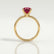 Lulu solitaire engagement ring in 18k yellow gold with an elongated cushion lab-grown ruby centre stone, side profile showing the setting and band.