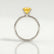 Lulu solitaire engagement ring in 18k white gold with an elongated cushion yellow lab-grown sapphire centre stone, side profile showing the setting and band.