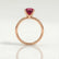 Lulu solitaire engagement ring in 18k rose gold with a cushion lab-grown ruby centre stone, side profile showing the setting and band.