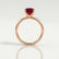 Lulu solitaire engagement ring in 18k rose gold with an emerald-cut lab-grown ruby centre stone, side profile showing the setting and band.