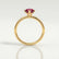 Lulu solitaire engagement ring in 18k yellow gold with a marquise lab-grown ruby centre stone, side profile showing the setting and band.