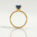 Lulu solitaire engagement ring in 18k yellow gold with a radiant lab-grown alexandrite centre stone, side profile showing the setting and band.