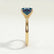 Lulu solitaire engagement ring in 18k yellow gold with a radiant lab-grown alexandrite centre stone, end-on view showing the setting and band.