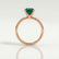 Lulu solitaire engagement ring in 18k rose gold with a radiant lab-grown emerald centre stone, side profile showing the setting and band.