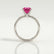 Lulu solitaire engagement ring with a radiant pink lab-grown sapphire centre stone, side profile showing the setting and band.