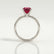Lulu solitaire engagement ring with a radiant lab-grown ruby centre stone, side profile showing the setting and band.