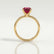 Lulu solitaire engagement ring in 18k yellow gold with a radiant lab-grown ruby centre stone, side profile showing the setting and band.