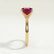 Lulu solitaire engagement ring in 18k yellow gold with a radiant lab-grown ruby centre stone, end-on view showing the setting and band.