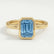 Front view of a blue emerald-cut lab-grown diamond engagement ring in a 18k yellow gold bezel setting