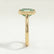 Side view of a green emerald-cut lab-grown diamond engagement ring in a 18k yellow gold bezel setting