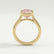 Side view of a pink emerald-cut lab-grown diamond engagement ring in a 18k yellow gold bezel setting