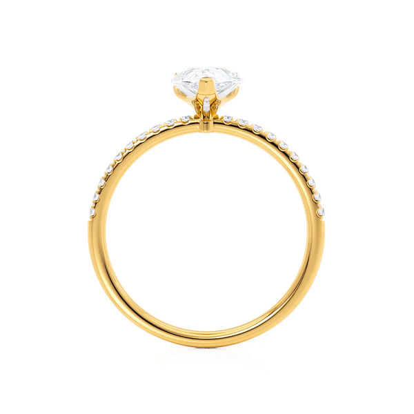 A solitaire engagement ring with a pear cut lab diamond centerpiece, set in a yellow gold band.