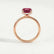Paris hidden halo engagement ring in 18k rose gold with an elongated cushion lab-grown ruby centre stone and diamond accents, side profile showing the setting and band.