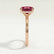 Paris hidden halo engagement ring in 18k rose gold with an elongated cushion lab-grown ruby centre stone and diamond accents, end-on view showing the setting and band.