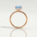 Paris hidden halo engagement ring in 18k rose gold with a princess-cut aquamarine-blue lab-grown sapphire centre stone and diamond accents, side profile showing the setting and band.