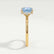 Paris hidden halo engagement ring in 18k yellow gold with a princess-cut aquamarine-blue lab-grown sapphire centre stone and diamond accents, end-on view showing the setting and band.