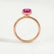Paris hidden halo engagement ring in 18k rose gold with a radiant pink lab-grown sapphire centre stone and diamond accents, side profile showing the setting and band.