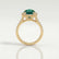 Rosa halo engagement ring in 18k yellow gold with an oval lab-grown emerald centre stone and diamond accents, side profile showing the setting and band.