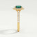 Rosa halo engagement ring in 18k yellow gold with an oval lab-grown emerald centre stone and diamond accents, end-on view showing the setting and band.