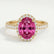 Rosa halo engagement ring in 18k yellow gold with an oval pink lab-grown sapphire centre stone and diamond accents, front view.