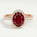 Rosa halo engagement ring in 18k rose gold with an oval lab-grown ruby centre stone and diamond accents, front view.