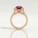 Rosa halo engagement ring in 18k rose gold with an oval lab-grown ruby centre stone and diamond accents, side profile showing the setting and band.
