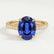 Viola shoulder-set engagement ring in 18k yellow gold with an oval blue lab-grown sapphire centre stone and diamond accents, front view.