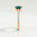 Viola shoulder-set engagement ring in 18k rose gold with an oval lab-grown emerald centre stone and diamond accents, end-on view showing the setting and band.
