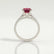 Viola shoulder-set engagement ring in platinum with an oval lab-grown ruby centre stone and diamond accents, side profile showing the setting and band.