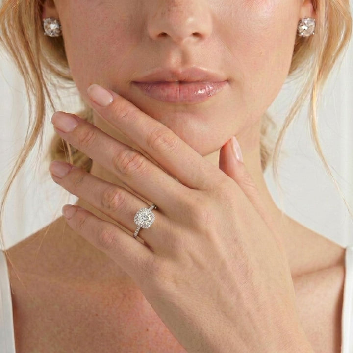 Video showing the Blush petite halo engagement ring with a round moissanite centre stone and diamond accents worn on a model's hand.