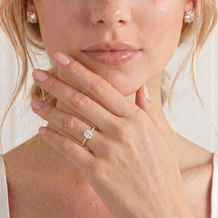 Video showing the Lively petite hidden halo with pavé shoulders engagement ring in 18k yellow gold with a cushion natural diamond centre stone worn on a model's hand.